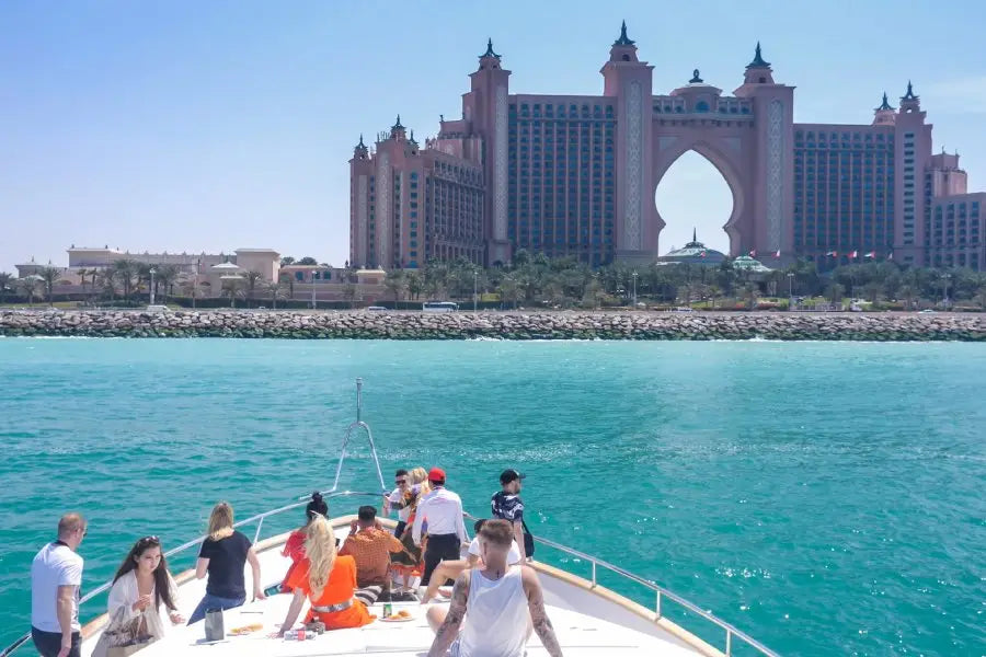 People on a boat with the Atlantis The Palm hotel in the background, Dubai.