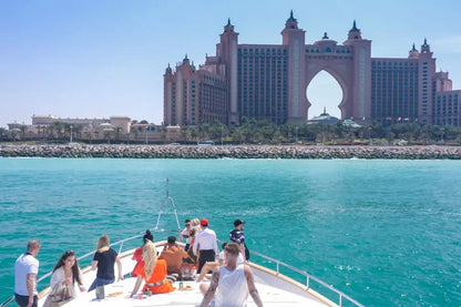 People on a boat with the Atlantis The Palm hotel in the background, Dubai.