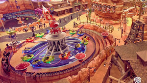 Amusement park ride with colorful cars around a central structure, surrounded by other attractions and visitors.