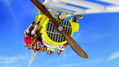 People on a roller coaster ride with a clear blue sky background