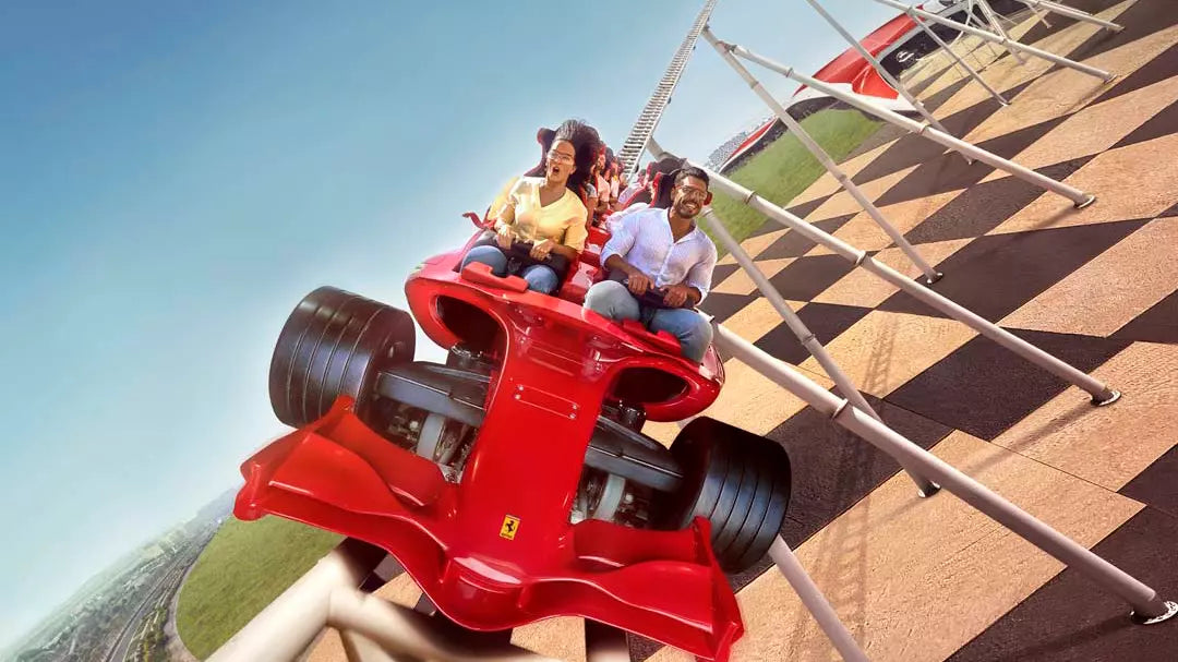 Red roller coaster car with people on a clear day