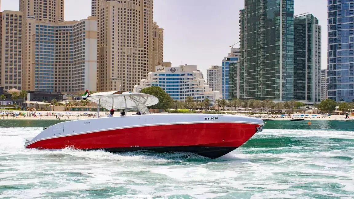 Red and white speedboat on water with city skyline in the background