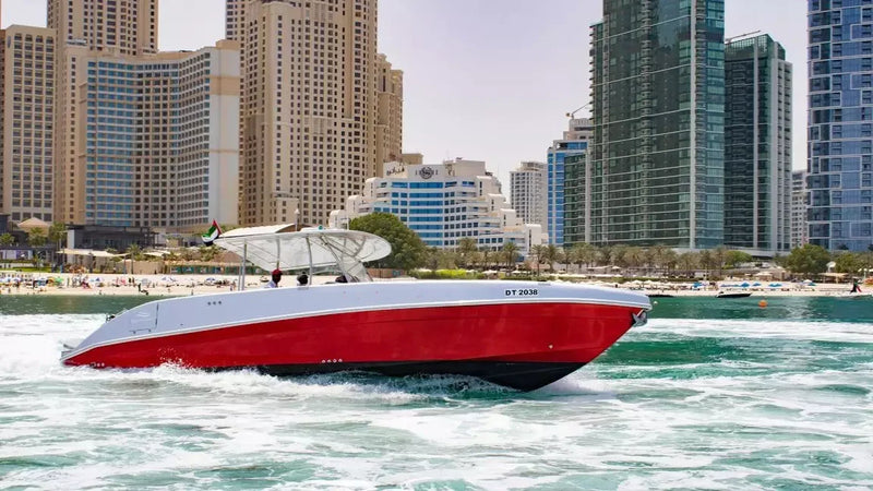 Red and white speedboat on water with city skyline in the background
