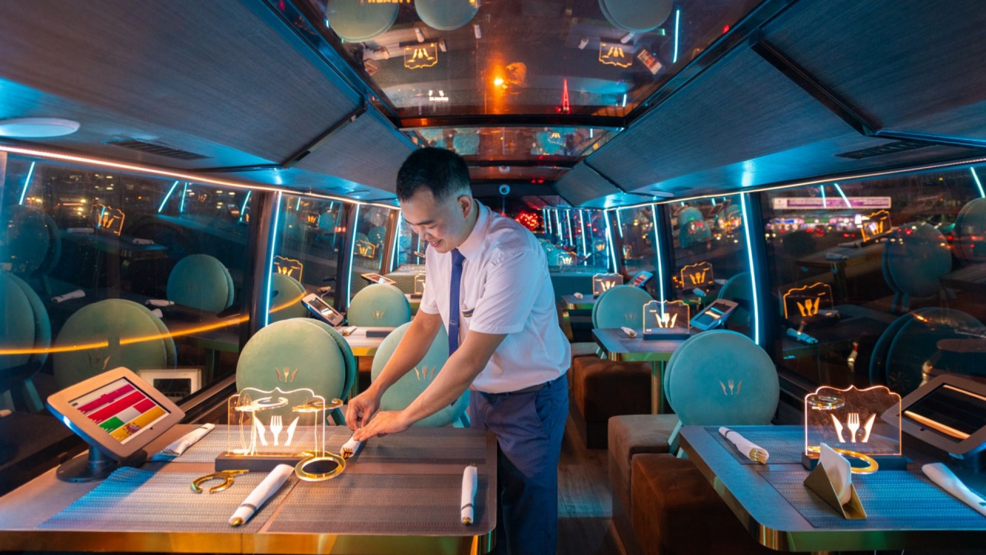 Person preparing a table inside a limousine with a modern interior.